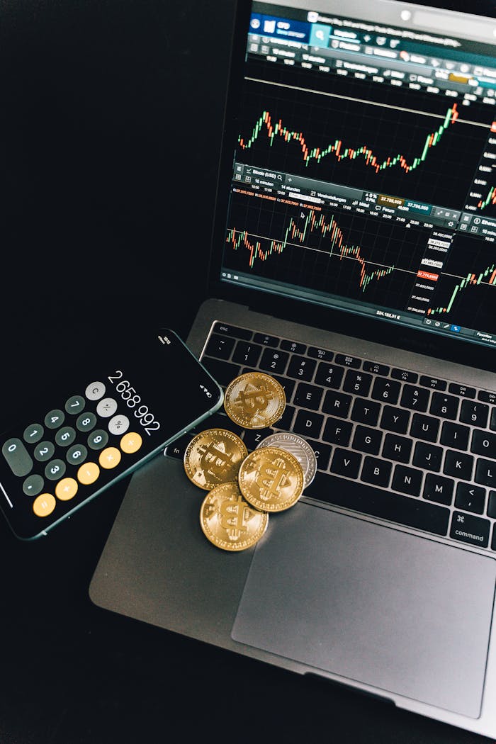 The Art of Drawing Readers In: Your attractive post title goes here A still life of Bitcoin coins, a smartphone calculator, and a trading chart on a laptop.